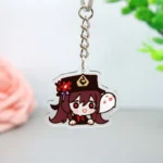Ein Acryl-Schlüsselanhänger mit einer Figur in einem Hut von Genshin Impact, mit leuchtenden Farben und kompliziertem Design.