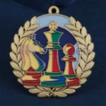 Medallas de ajedrez de oro, plata y bronce personalizadas expuestas sobre un tablero, que destacan los logros en competiciones de ajedrez.