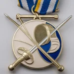 Eine individuelle Fechtmedaille mit zwei gekreuzten Schwertern und einem blauen Band als Symbol für sportliche Leistungen.