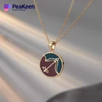 Eine Frau präsentiert eine Schütze-Halskette aus zarter Emaille mit einer goldenen Kette und einem auffälligen lila Anhänger.
