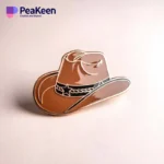 Alfiler de sombrero vaquero mostrado sobre un fondo blanco limpio, mostrando su diseño y detalles.