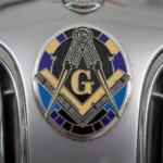 A close-up of a car's front featuring a prominent Masonic emblem, symbolizing fraternity and tradition.