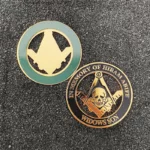 Two Masonic pins featuring emblems displayed on a black surface, highlighting their intricate designs and symbolism.