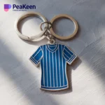 Un llavero de jersey diseñado como una camiseta a rayas azules y blancas, ideal para añadir un toque deportivo a tus llaves.