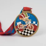 Medaille mit einer verspielten Zeichentrickfigur, die auf einem Balance-Bike fährt.