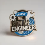 A pin featuring the phrase "Trust me, I'm an engineer" in bold letters, showcasing a playful engineering theme.