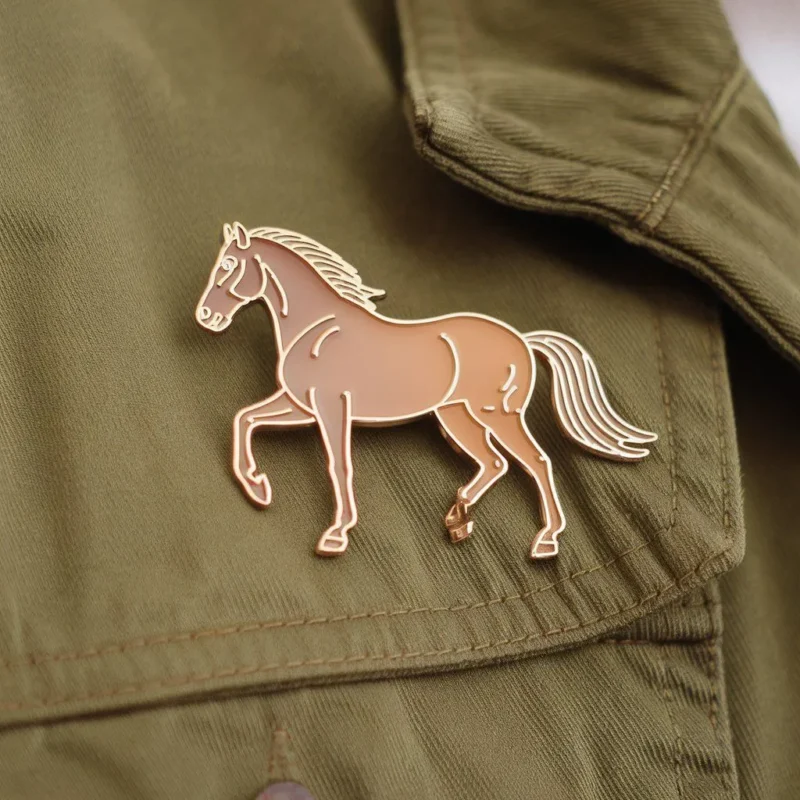 Eine braune Pferdenadel auf einer Jacke, die den Reitstil unterstreicht.