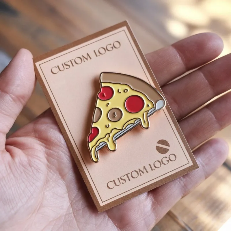 Eine Hand, die eine Anstecknadel mit einem Pizzamotiv hält, die an einer Grußkarte befestigt ist, zeigt ein lustiges und verspieltes Design.