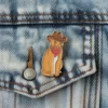 Eine verspielte Anstecknadel, die eine Katze mit Cowboyhut zeigt, aus der Serie Cowboy Cat Pins.