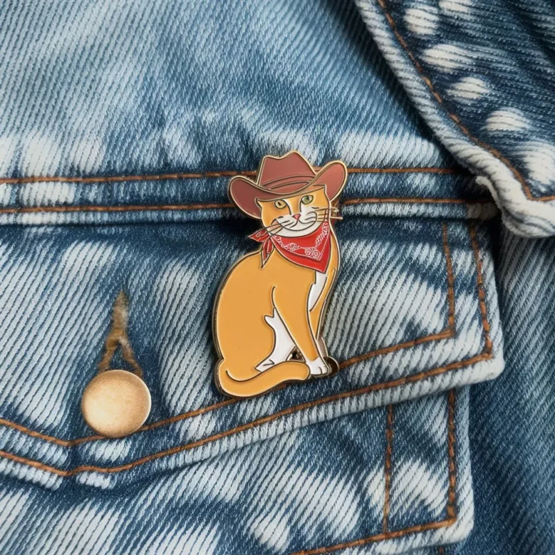 Eine skurrile Anstecknadel mit einer Katze mit Cowboyhut, Teil der Cowboy Cat Pins Serie.
