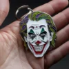 Una persona sostiene un llavero joler con un colorido diseño de la cara de un bromista.