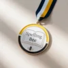 Eine dekorative Medaille mit der Aufschrift "Spelling Bee", die für hervorragende Leistungen in Rechtschreibwettbewerben verliehen wird.